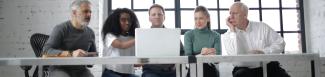A group of people looking at a computer in an office