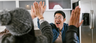 A group of people in a kitchen high fiving
